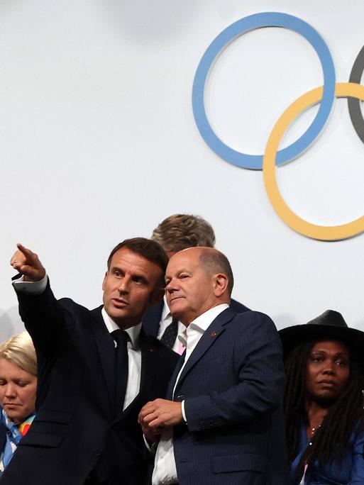 Bundeskanzler Olaf Scholz hält ein  Gespräch mit Frankreichs Staatspräsident Emmanuel Macron auf der Tribüne bei den Olympische Spielen von Paris. 