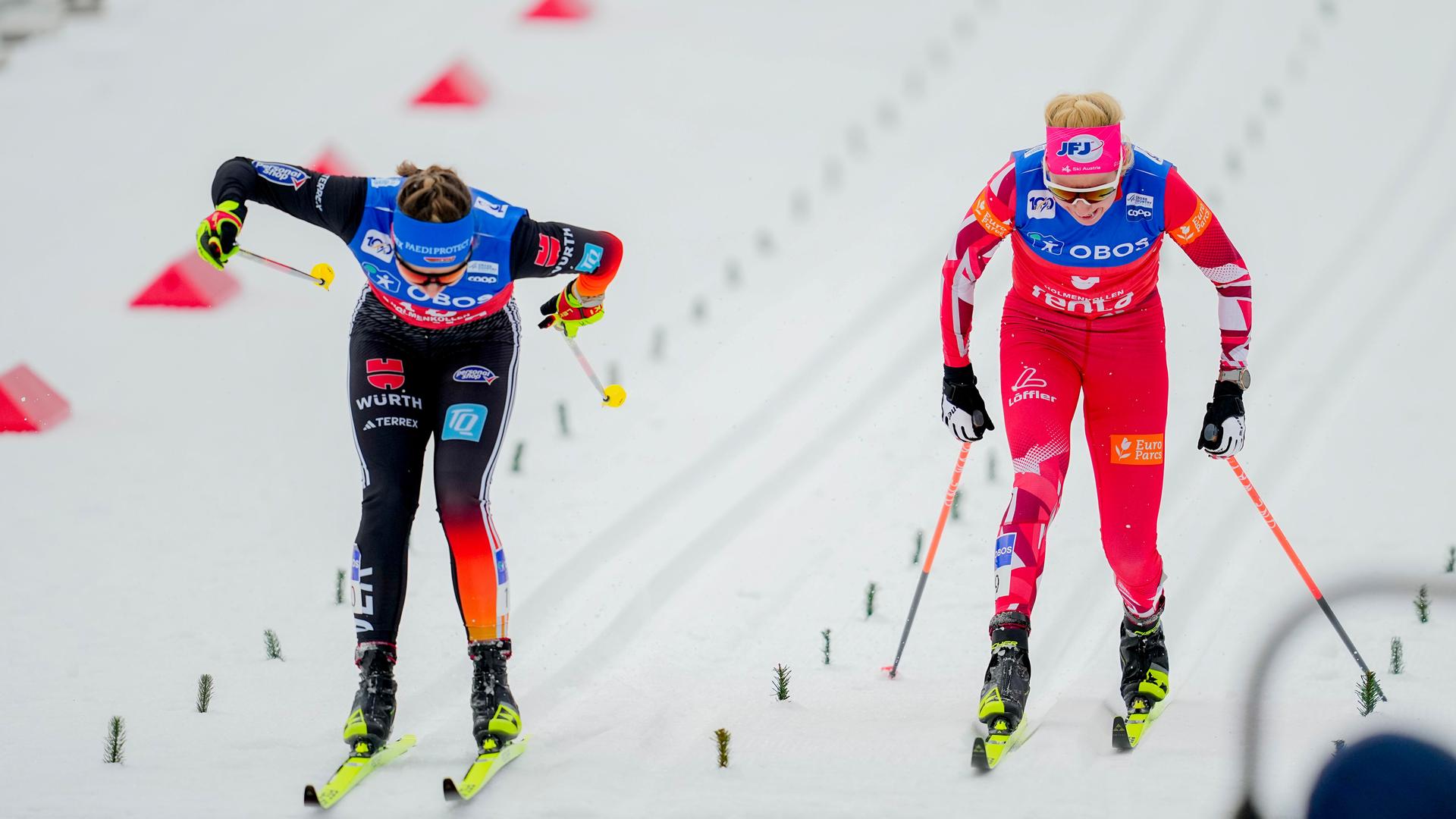 Zwei Ski-Langläuferinnen schieben sich mit ihren Stöcken im Sprint über die Ziellinie.