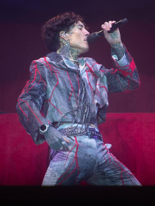 Oli Sykes singt beim Reading Festival 2025 ins Mikro. Der Sänger von "Bring Me The Horizon" ist von der Seite zu sehen,. 