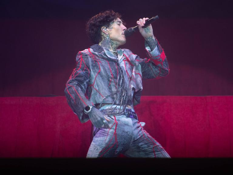 Oli Sykes singt beim Reading Festival 2025 ins Mikro. Der Sänger von "Bring Me The Horizon" ist von der Seite zu sehen,. 