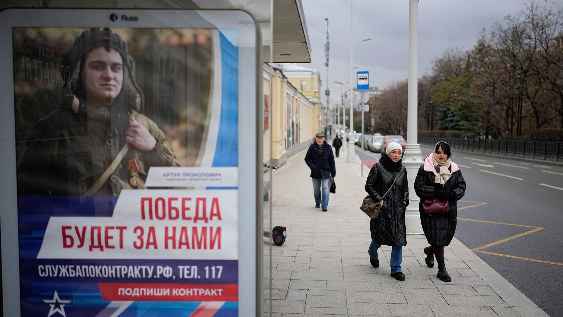 Auf einem Plakat an einer Bushaltestelle in Moskau ist ein Soldat zu sehen und die Parole "Der Sieg wird unser sein" zu lesen.