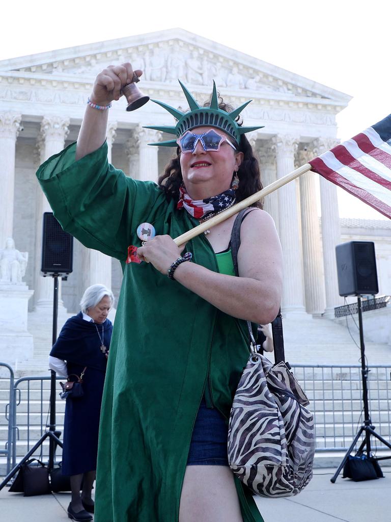 Eine als Freiheitsstatue verkleidete Person läutet eine Glocke während einer Kundgebung zur Unterstützung des Geburtsortsprinzips vor dem Obersten Gerichtshof der USA.
