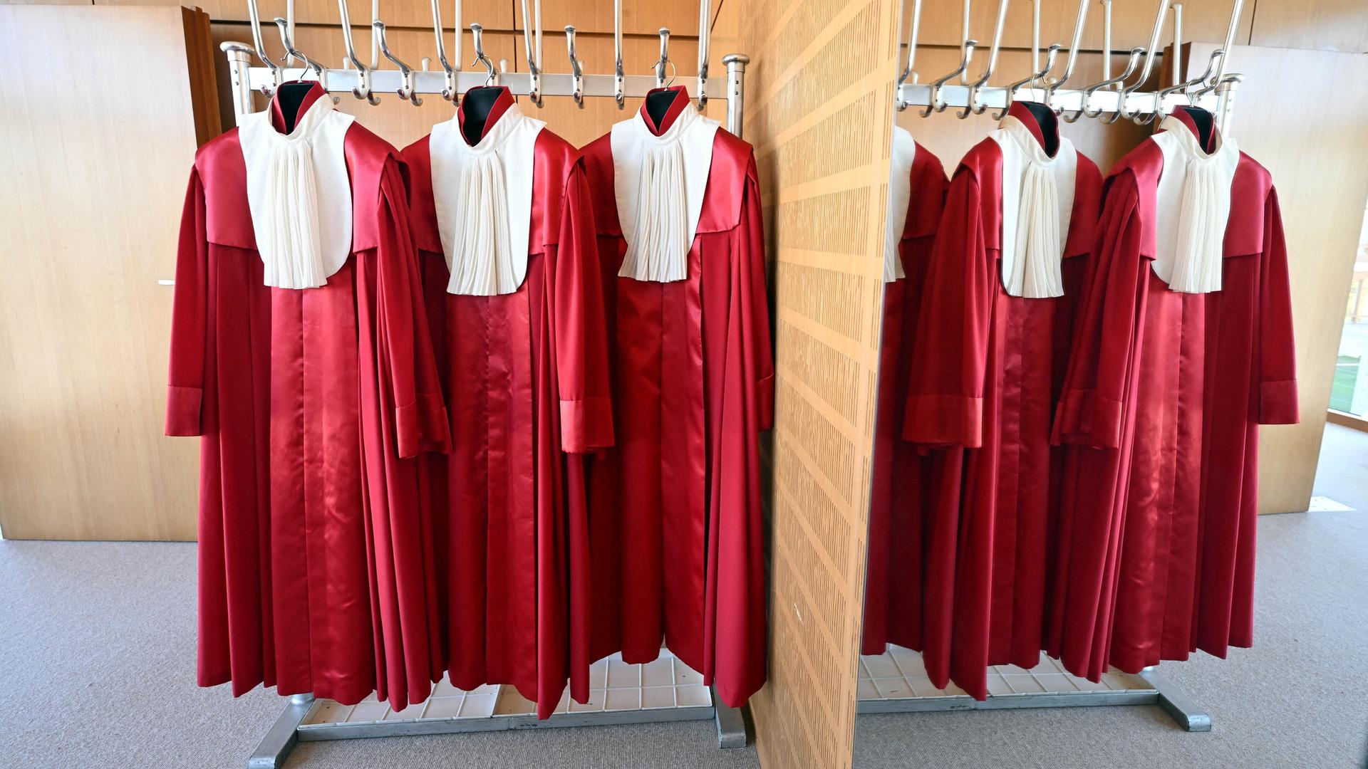 Die roten Roben der Bundesverfassungsrichter hängen in einer Garderobe nebeneinander an Haken. Die roten Roben der Bundesverfassungsrichter hängen in einer Garderobe nebeneinander an Haken.