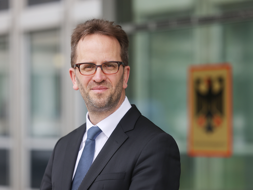 Klaus Müller, Präsident der Bundesnetzagentur, steht vor dem Haus der Bundesnetzagentur.