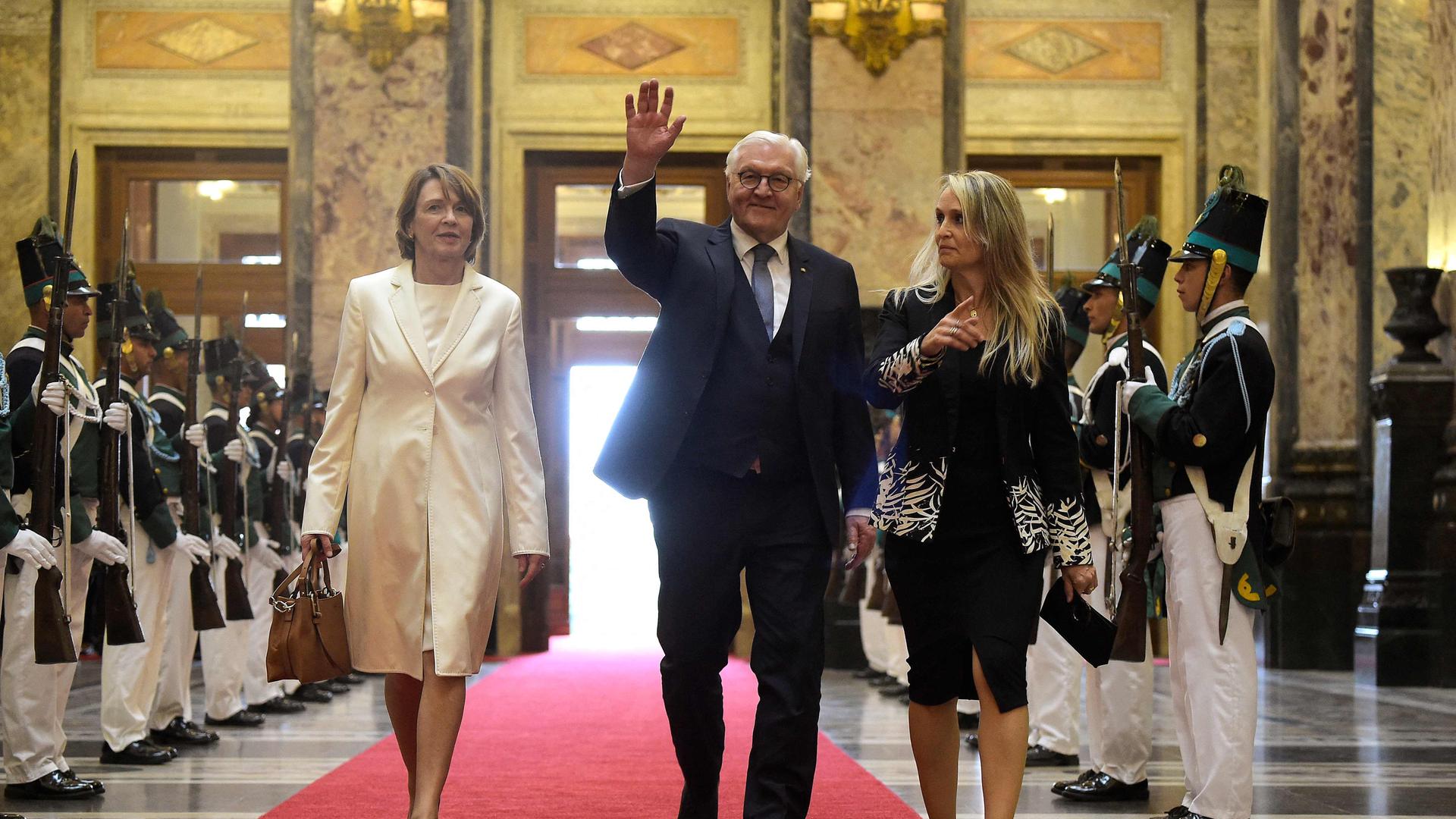 Bundespräsident Steinmeier geht gemeinsam mit seiner Frau über einen roten Teppich.