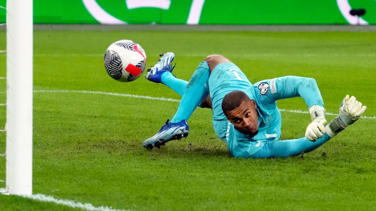 Irlands Torwart Bazunu im blauen Trikot hechtet nach einem Ball und blickt ihm hinterher.