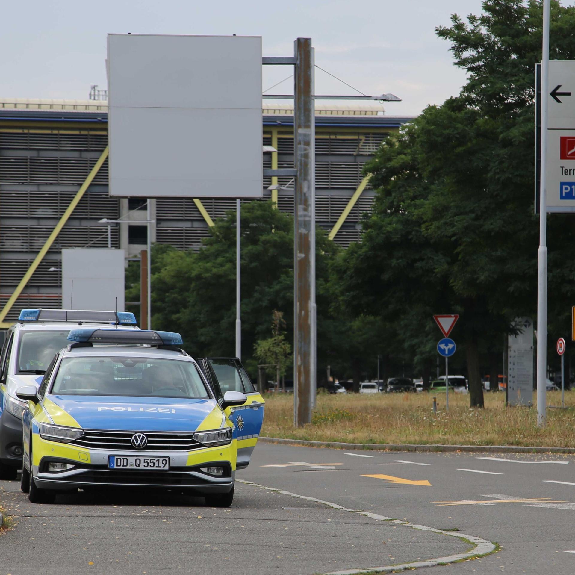 Polizeifahrzeuge stehen vor Zufahrt der Flughafenverwaltung am Flughafen Leipzig/Halle.