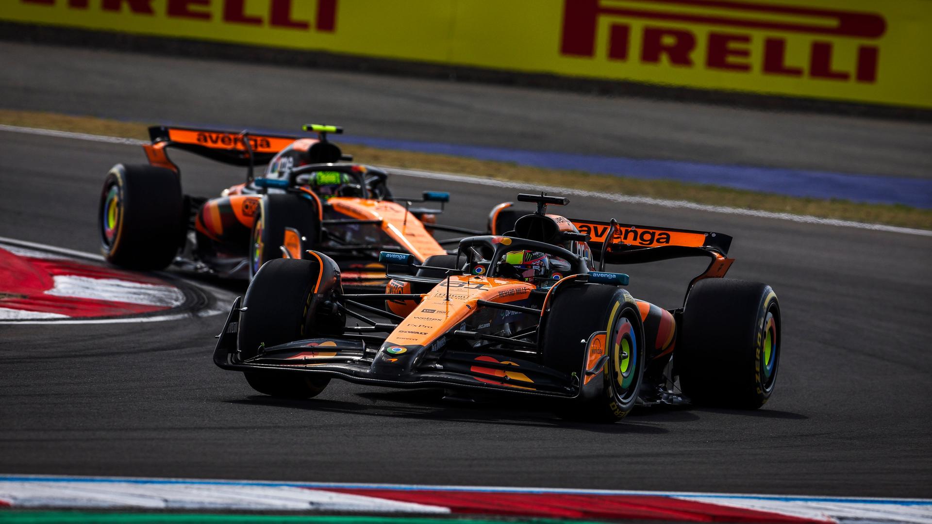 Zwei Formel1-Wagen von McLaren fahren dicht hintereinander. Zwei Formel1-Wagen von McLaren fahren dicht hintereinander.
