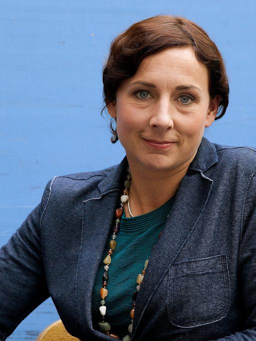Juli Zeh in blauer Jacke lächelt in die Kamera. Juli Zeh in blauer Jacke lächelt in die Kamera.
