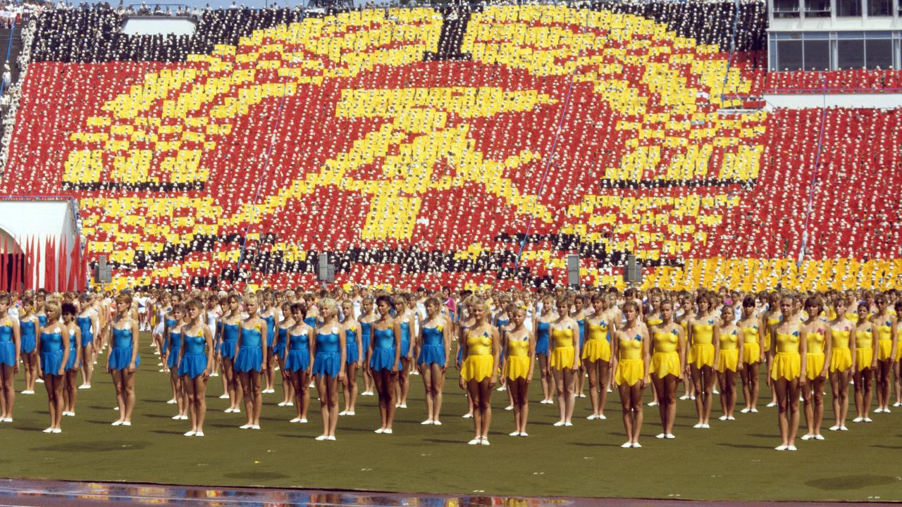 In überdimensionaler Größe wird am 30.07.1987 das aus Hammer, Zirkel und Ehrenkranz bestehende Staatssymbol der DDR von Tausenden Teilnehmern des VIII. Turn- und Sportfestes auf den Rängen des Leipziger Zentralstadions gebildet.