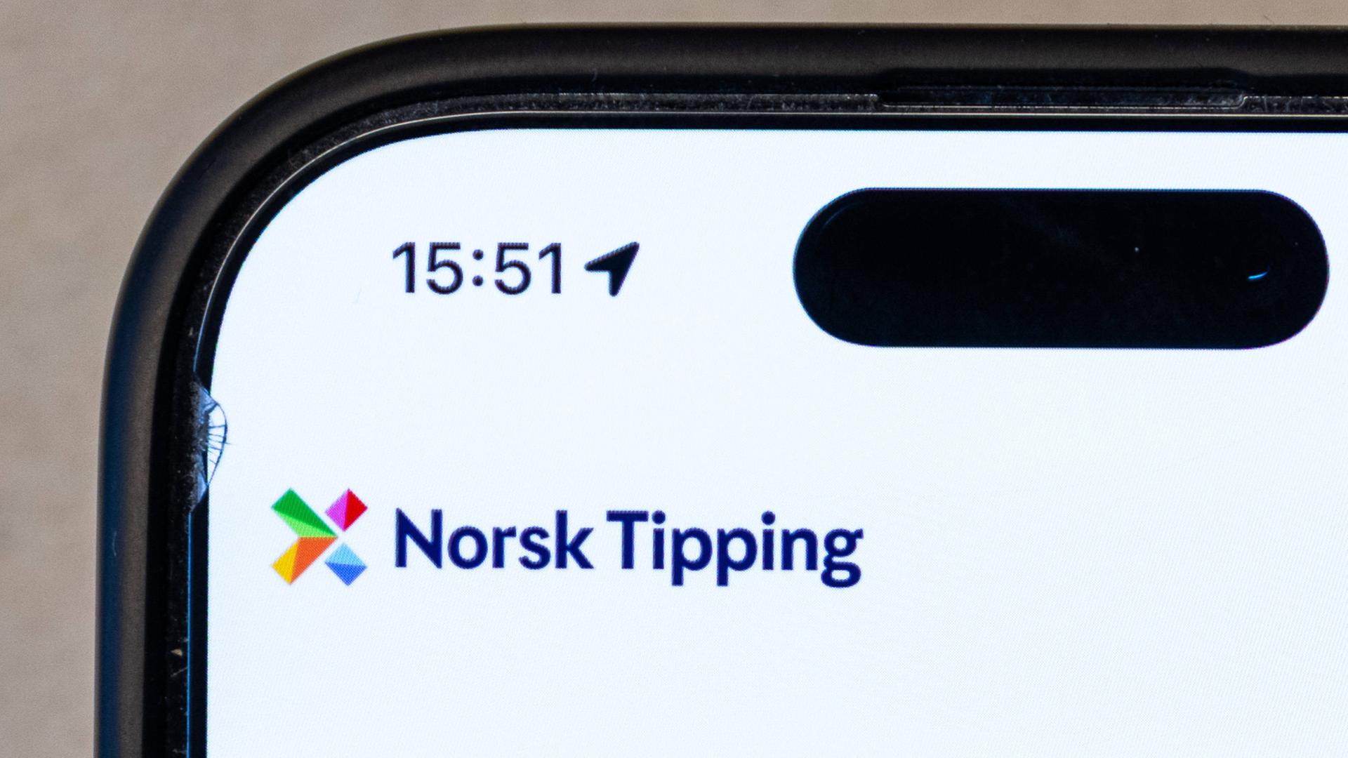Das Logo von Norsk Tipping auf einem Handy Das Logo von Norsk Tipping auf einem Handy