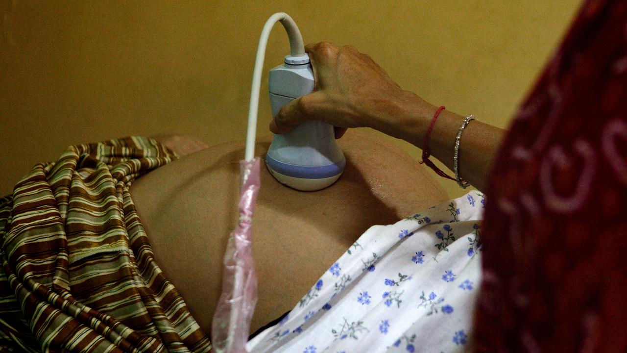 Eine schwangere Frau bei der Ultraschallbehandlung in einer indischen Klinik Eine schwangere Frau bei der Ultraschallbehandlung in einer indischen Klinik