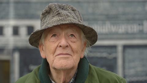 Regisseur Hans-Jürgen Syberberg steht am 28.09.2017 in Demmin (Mecklenburg-Vorpommern) auf dem Markt und blickt zum verregneten Himmel leicht nach oben. 