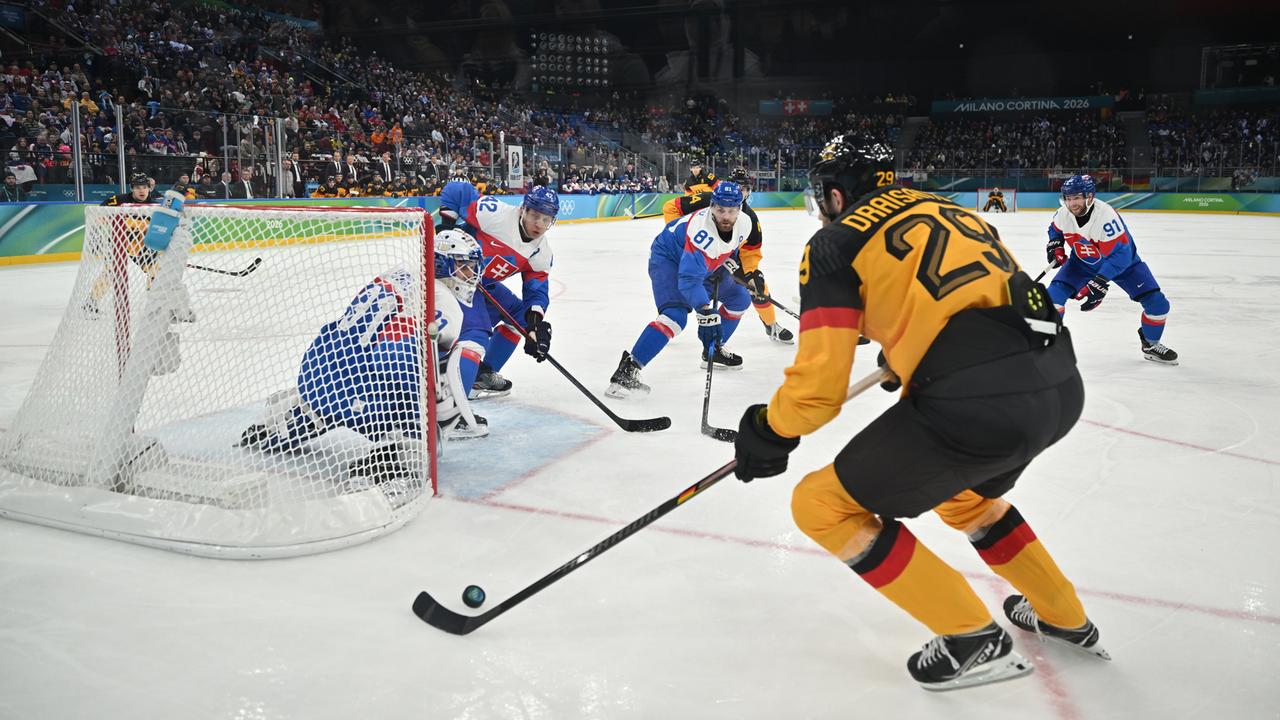 Eishockey-Spieler Leon Draisaitl steht im deutschen Trikot am Puck vor dem slowakischen Tor.