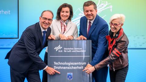 Eröffnung des Technologiezentrusm für Drohnensicherheit und präsentieren die Stele mit dem Schriftzug der Einrichtung.