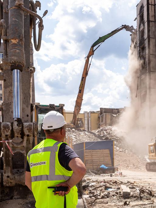 Baurbeiter in gelber Warnweste überwacht Wiederaufbau von Wohnhäusern in Irpin, Ukraine am 13. Mai 2023