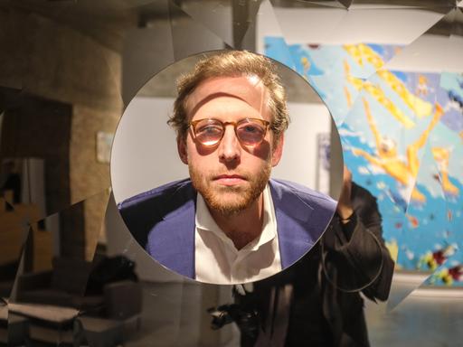 Johann König schaut schaut durch ein Fenster seiner Galerie in Berlin