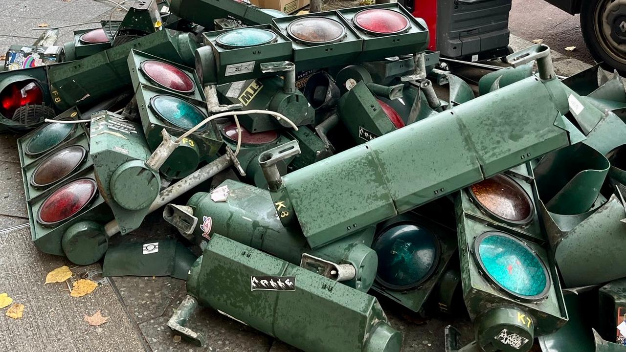 An einer Berliner Straßenecke lagern zahlreiche demontierte Verkehrsampeln.