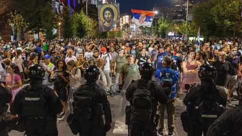 Demonstranten mit der serbischen Flagge stehen in Belgrad der Polizei gegenüber