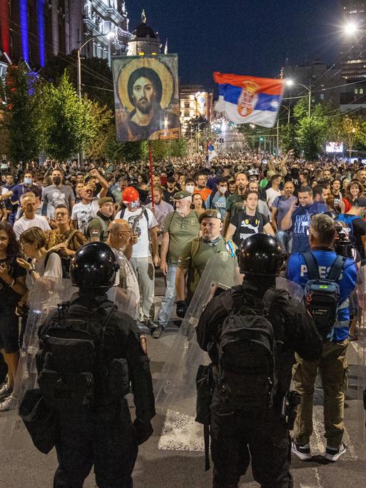 Demonstranten mit der serbischen Flagge stehen in Belgrad der Polizei gegenüber
