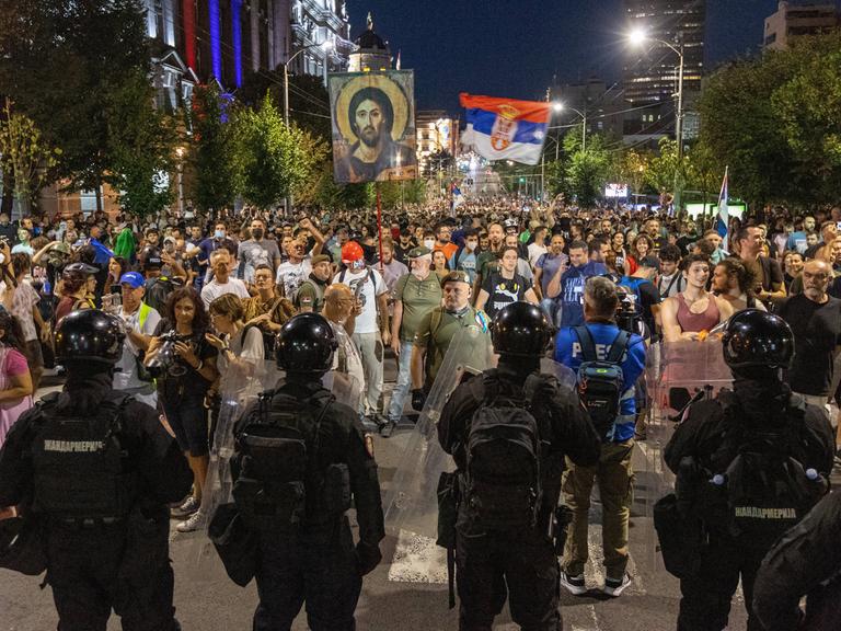 Demonstranten mit der serbischen Flagge stehen in Belgrad der Polizei gegenüber