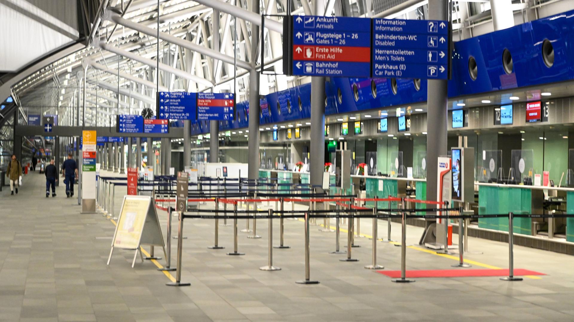 Eine Abflughalle eines Flughafens mit leeren Schaltern und Wartereihen