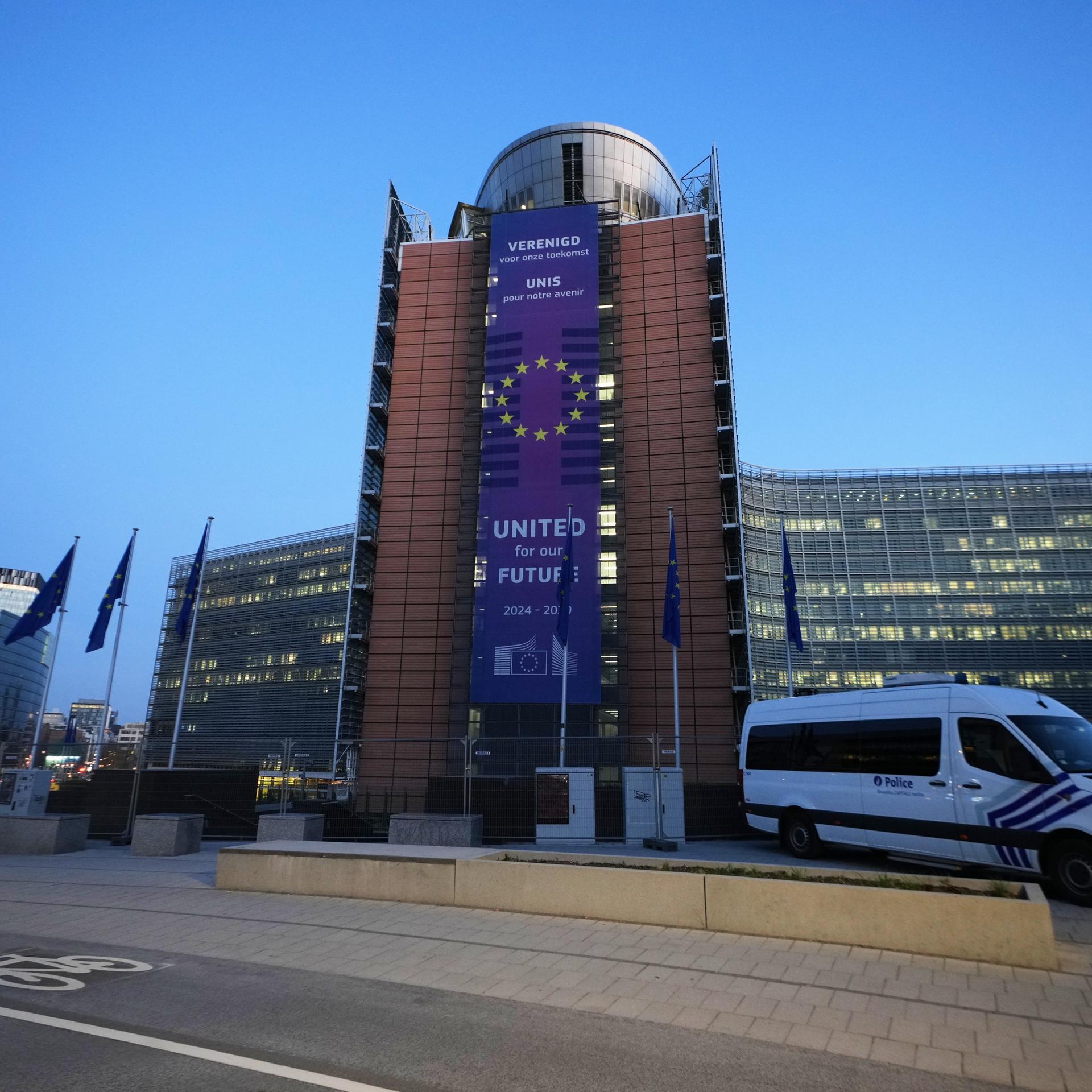 Vor dem Gebäude der EU in Brüssel fährt ein Polizeiwagen.