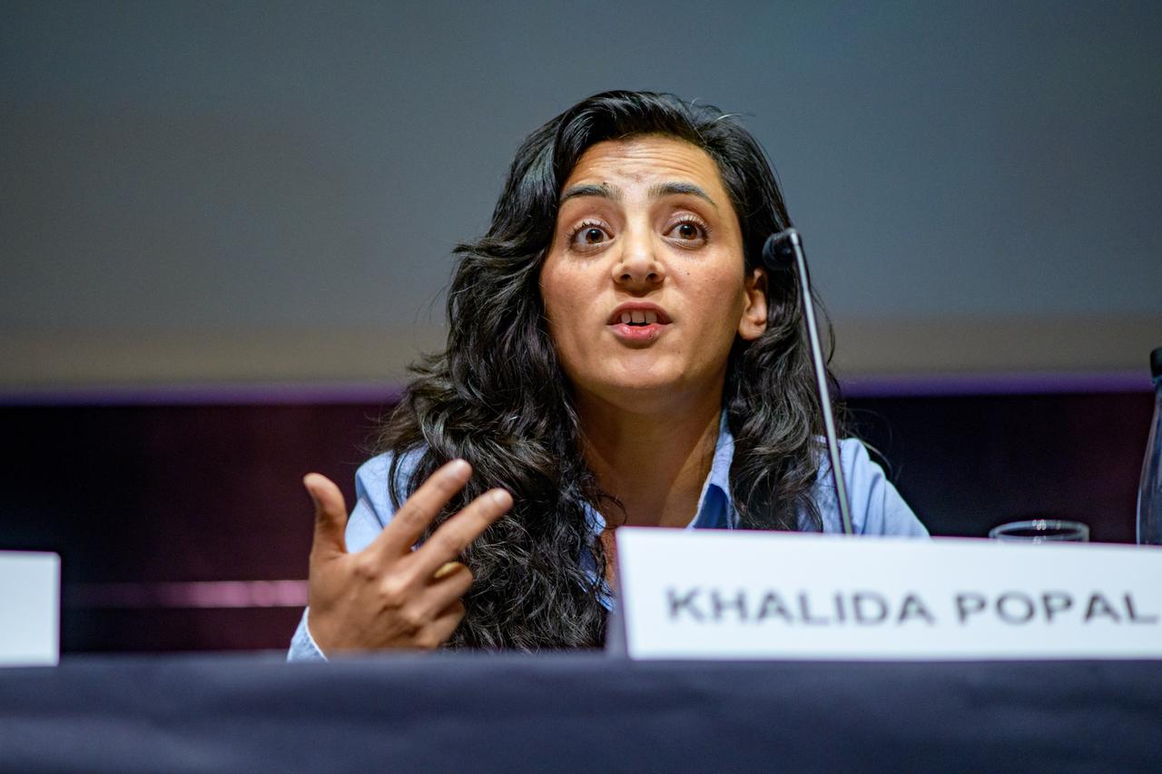 Khalida Popal spricht auf einem Podium ins Mikrofon