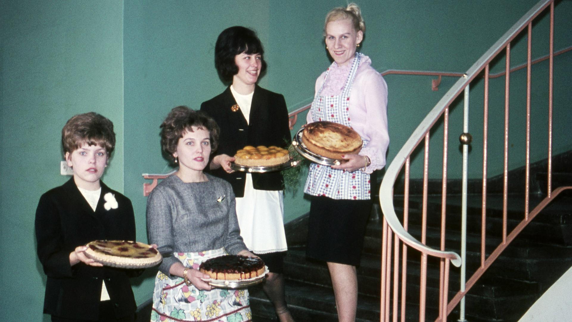 Vier Hausfrauen mit frisch gebackenem Kuchen stehen auf einer Treppe, ca. 1960.