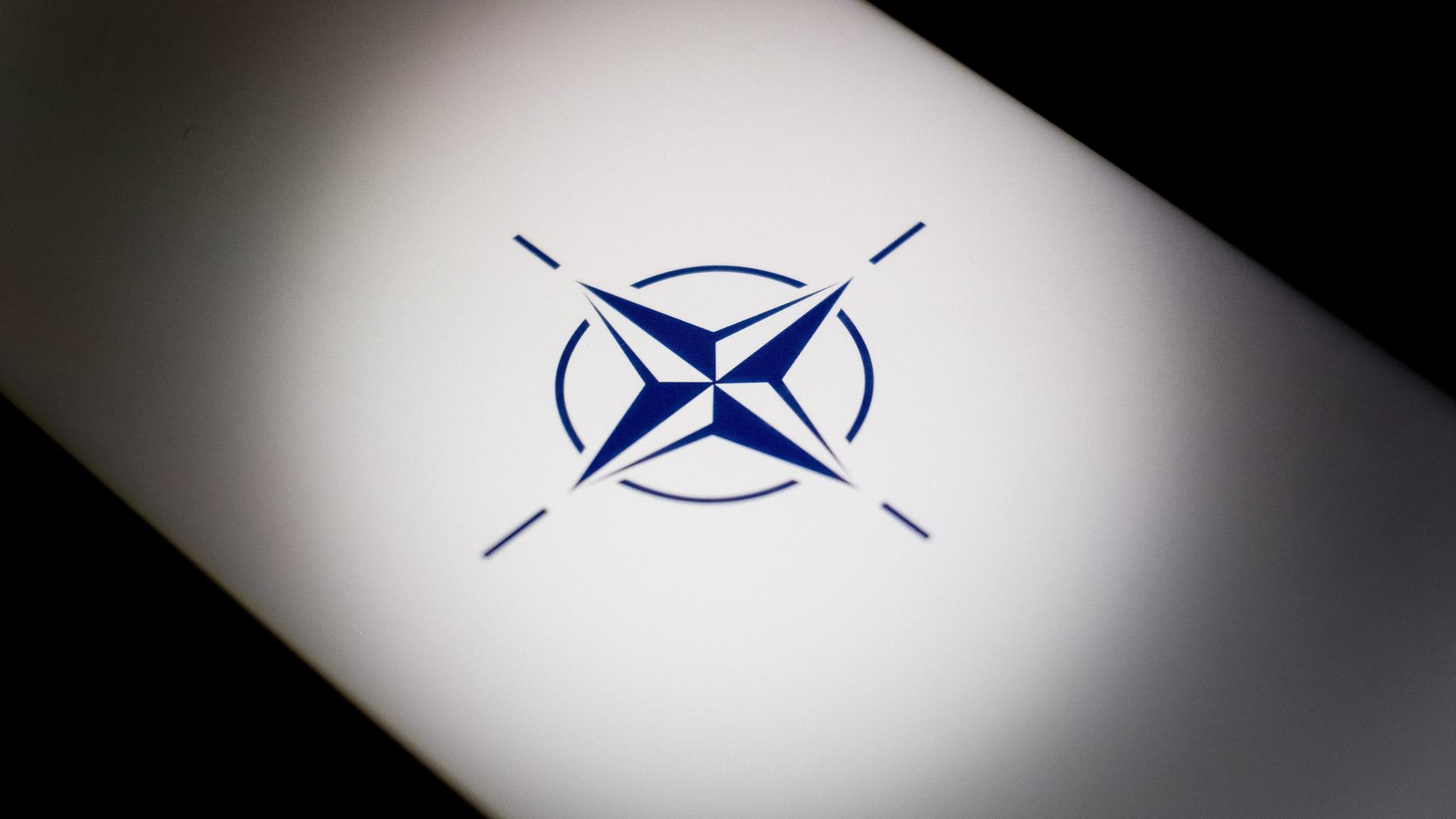Ein hinterleuchtetes NATO-Logo ist zu sehen.