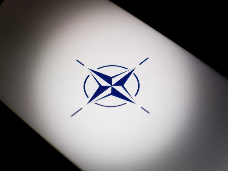 Ein hinterleuchtetes NATO-Logo ist zu sehen.