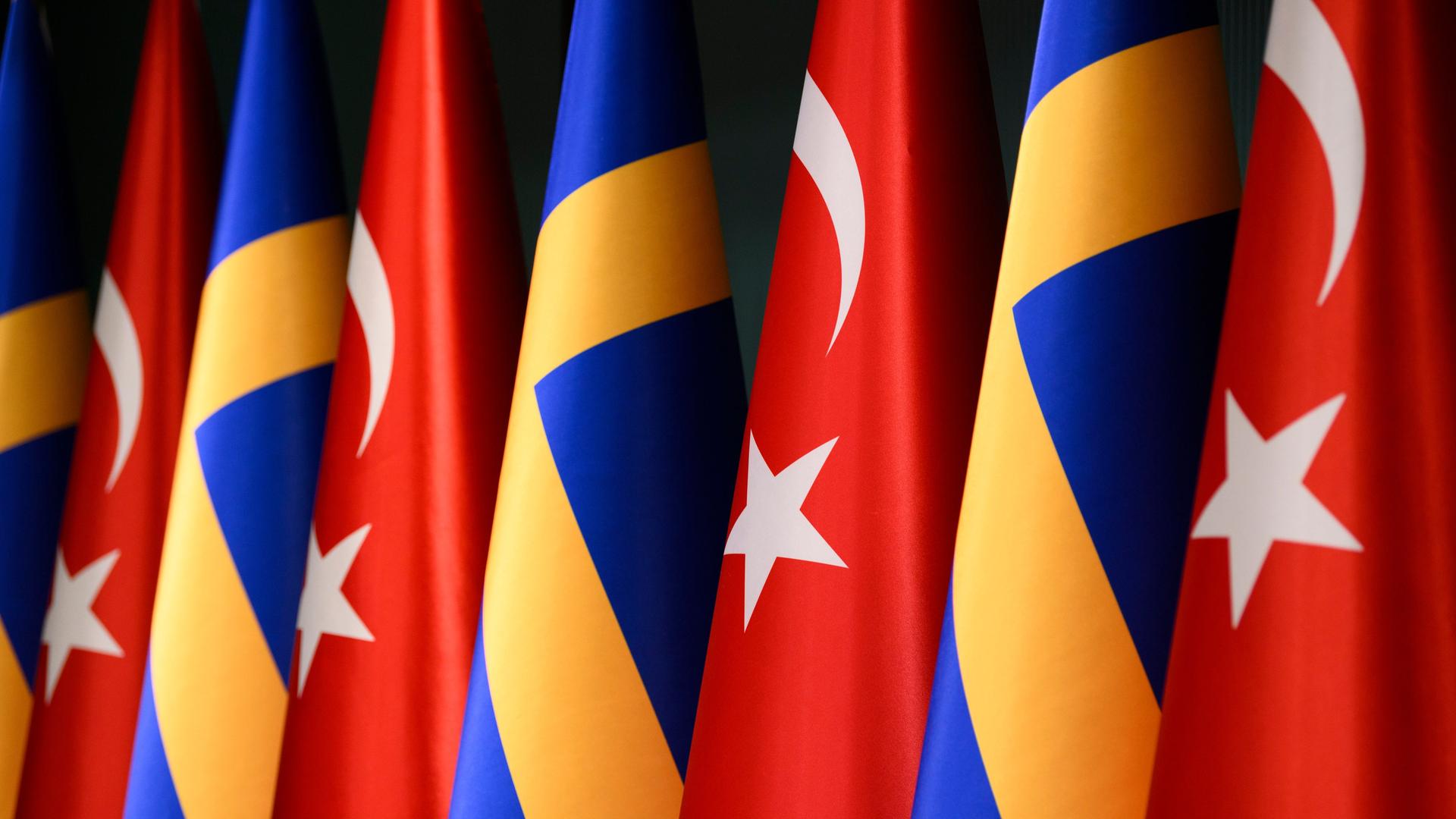 Mehrere schwedische und türkische Fahnen hängen nebeneinander.