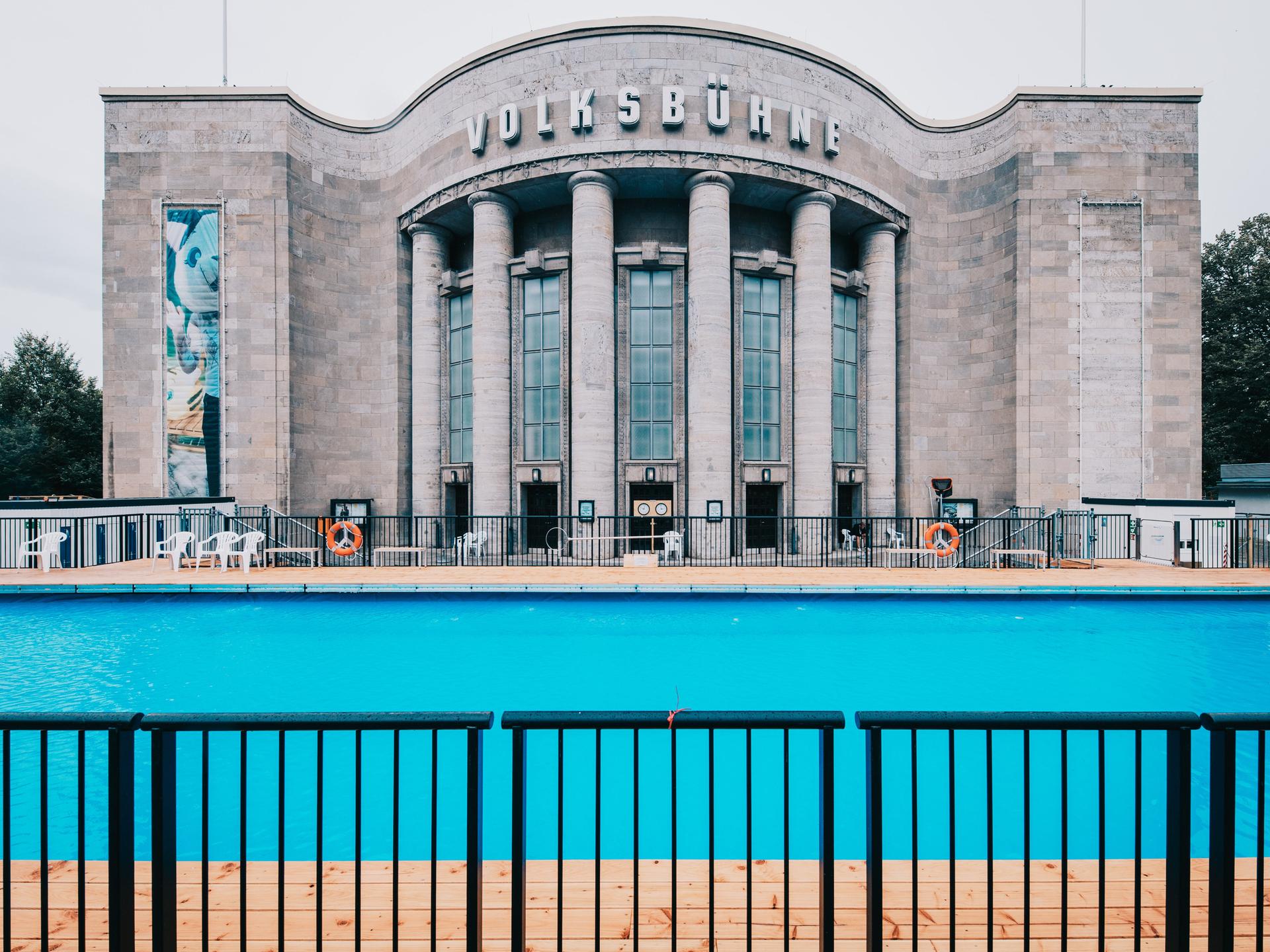 Das Volksbadmit blauem Wasser vor der Volksbühne in Berlin bei Nieselregen am Ruhetag. 