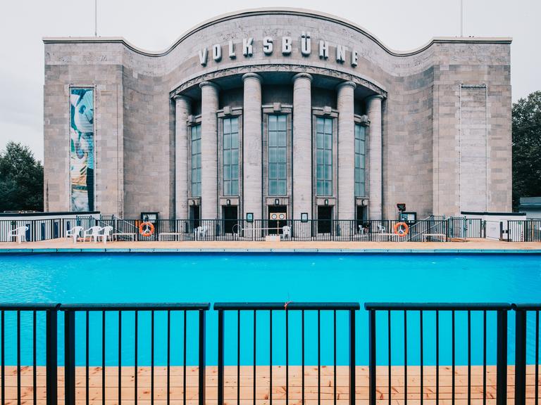 Das Volksbadmit blauem Wasser vor der Volksbühne in Berlin bei Nieselregen am Ruhetag. 