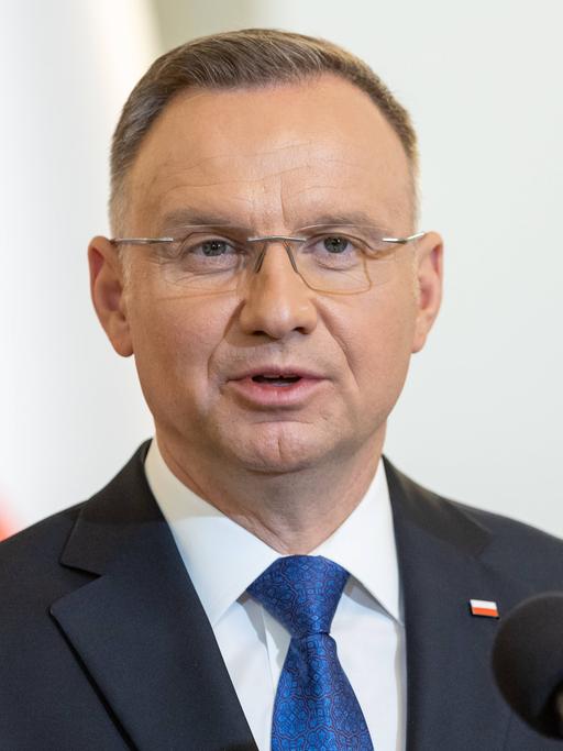 Polens Präsident Duda steht im Anzug vor einer polnischen Flagge an einem Rednerpult.