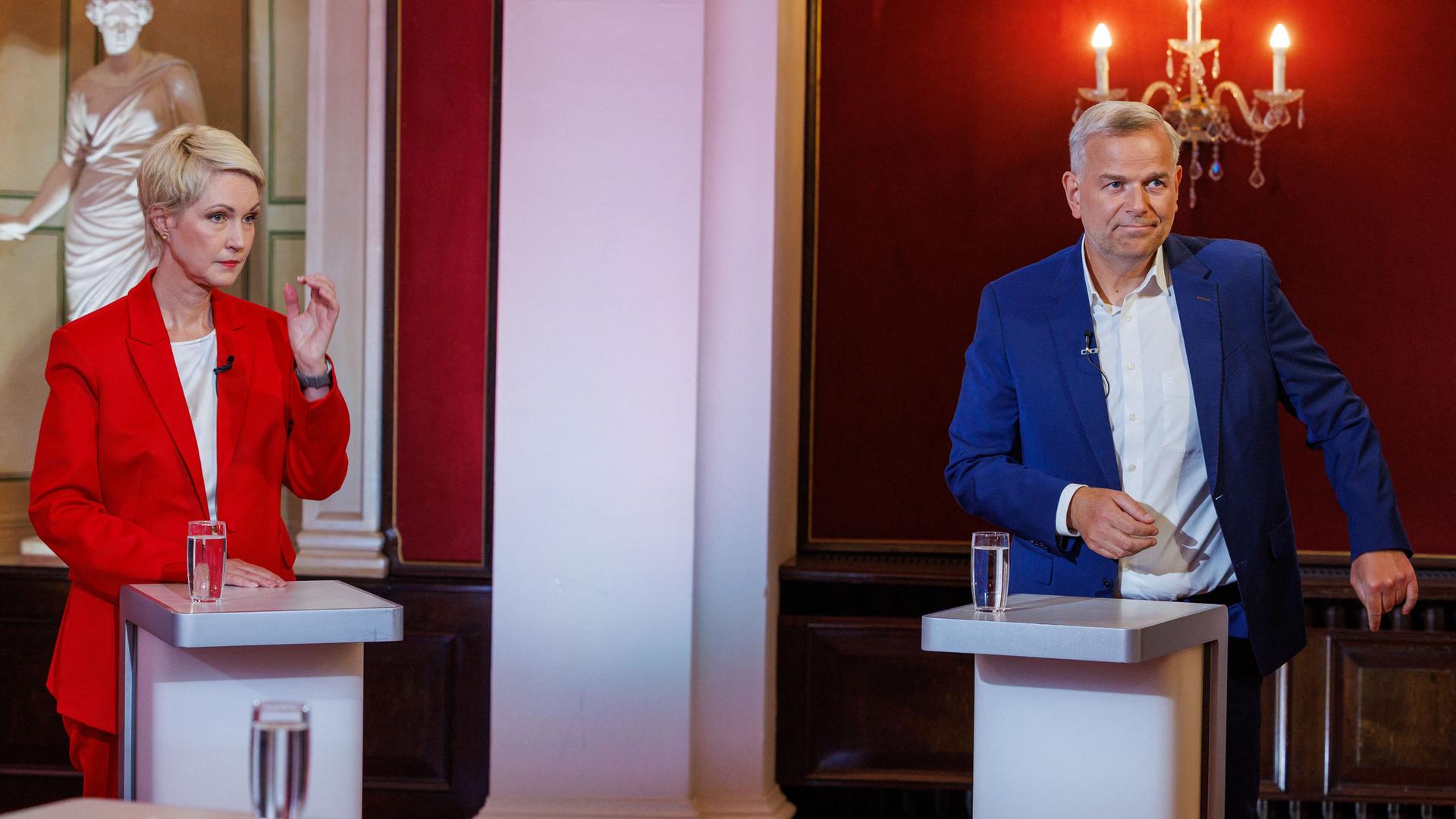 Manuela Schwesig und Leif-Erik Holm stehen bei einem TV-Duell deutlich voneinander getrennt an zwei Redepulten und reagieren auf die Fragen der Moderatorin. Manuela Schwesig und Leif-Erik Holm stehen bei einem TV-Duell deutlich voneinander getrennt an zwei Redepulten und reagieren auf die Fragen der Moderatorin.