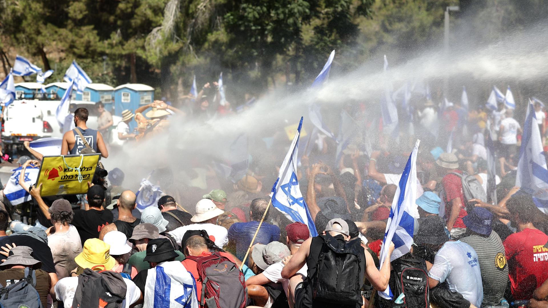 Die Polizei in dem Land Israel setzt Wasser-Werfer gegen Demonstranten ein. 