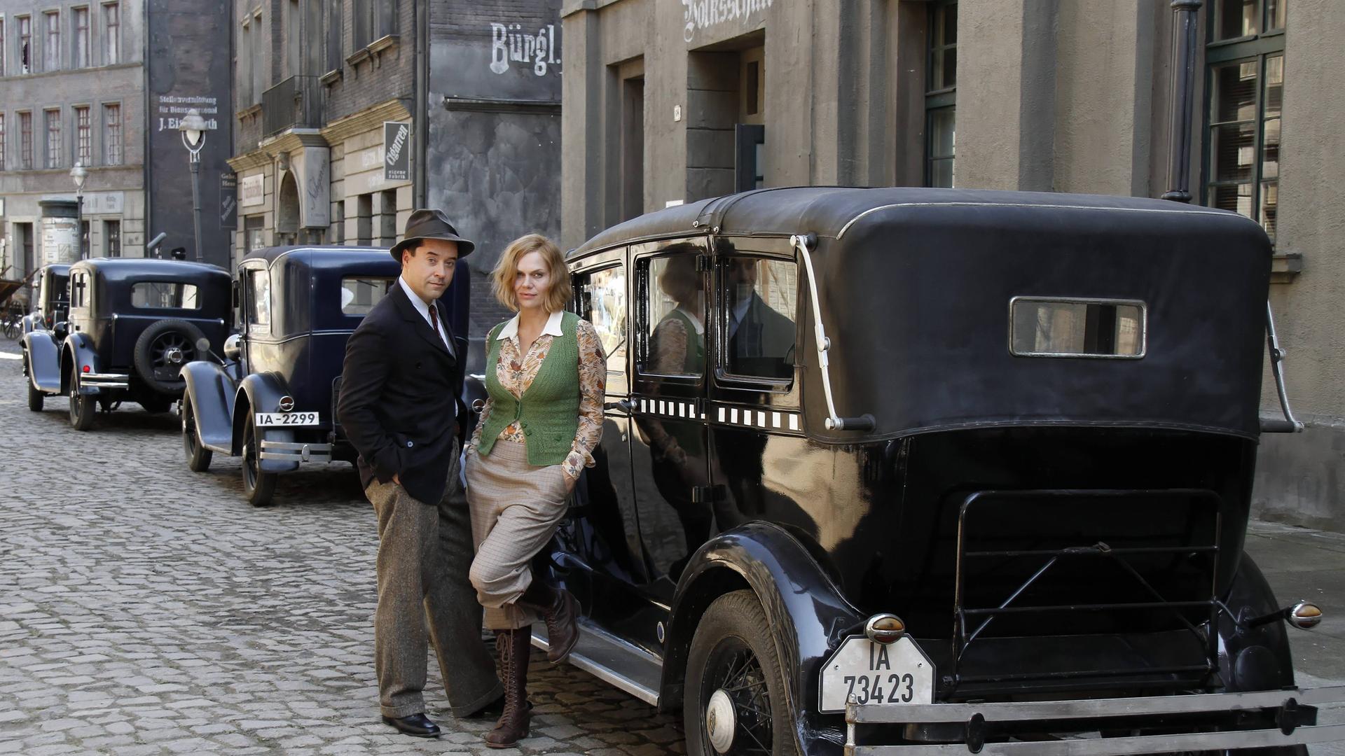 Die Schuspieler Jan Josef Liefers und Anna Loos in historischer Kulisse am Filmset