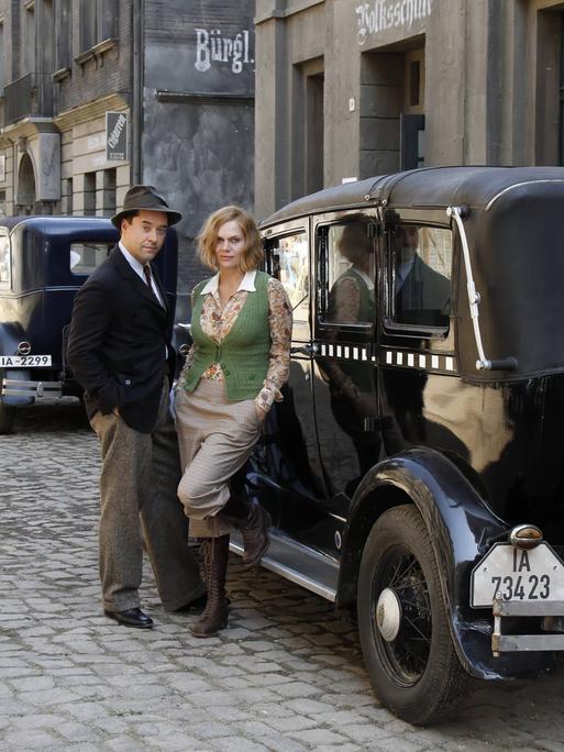 Die Schuspieler Jan Josef Liefers und Anna Loos in historischer Kulisse am Filmset