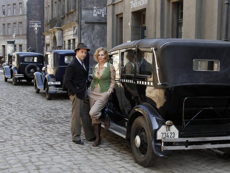 Die Schuspieler Jan Josef Liefers und Anna Loos in historischer Kulisse am Filmset