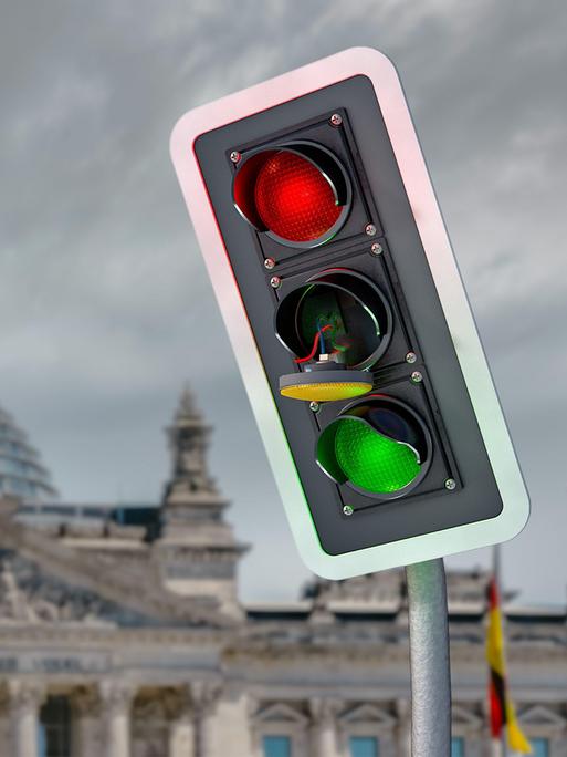 Eine Fotomontage zeigt eine ramponierte Ampel mit einem herausgesprungenen Gelb-Licht vor dem Hintergrund des Reichstagsgebäudes.