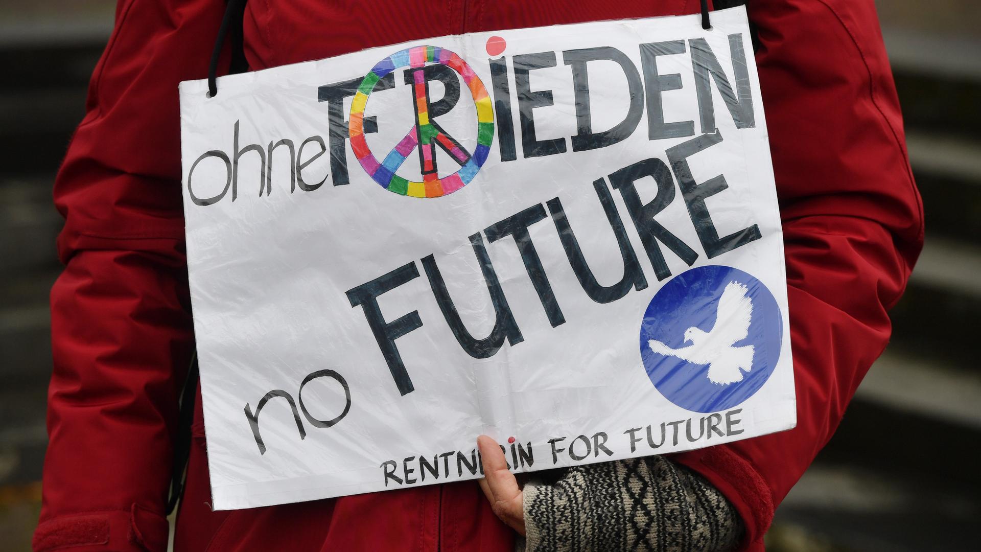 Auf einem Plakat, das eine ältere Frau vor sich hält, steht "Ohne Frieden no Future - Rentnerin for future".