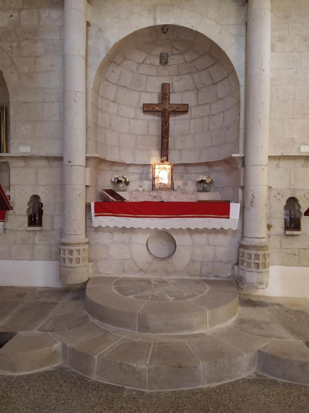 Im Inneren der Kirche hängt ein Kreuz an der Wand. 