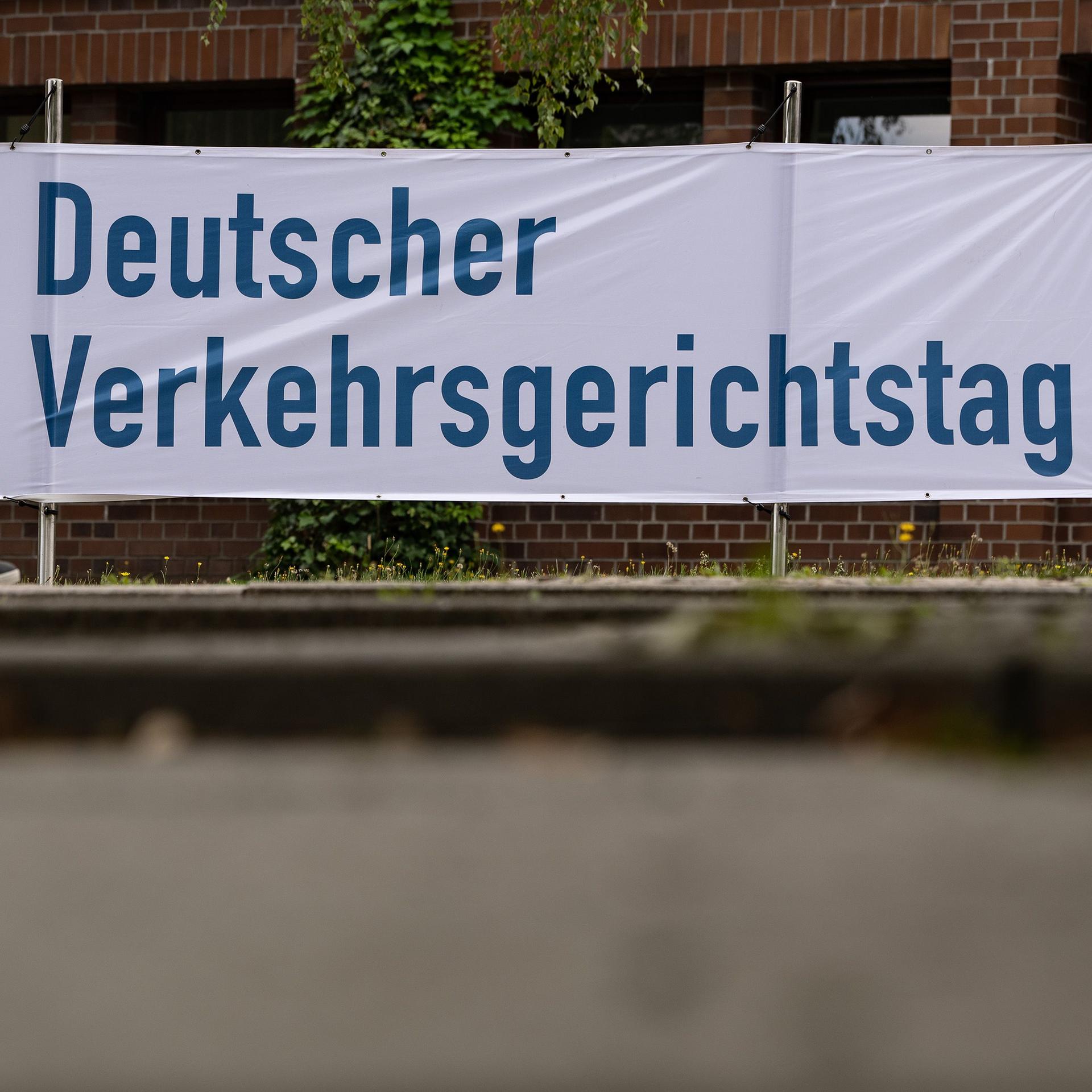 17.08.2022, Niedersachsen, Goslar: Ein Mann geht an einem Banner mit der Aufschrift «Deutscher Verkehrsgerichtstag» vorbei