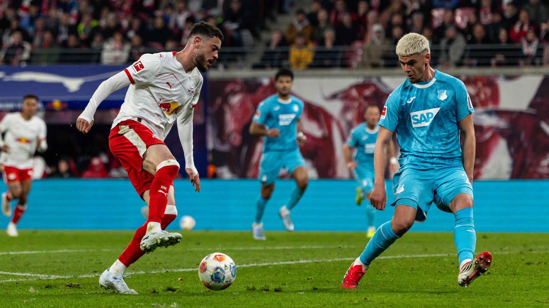 Romulo Cardoso von RB Leipzig und Albian Hajdari von der TSG Hoffenheim kämpfen um den Ball. Cardoso trägt ein weiß-rotes Trikot, Hajdari ein hellblaues.