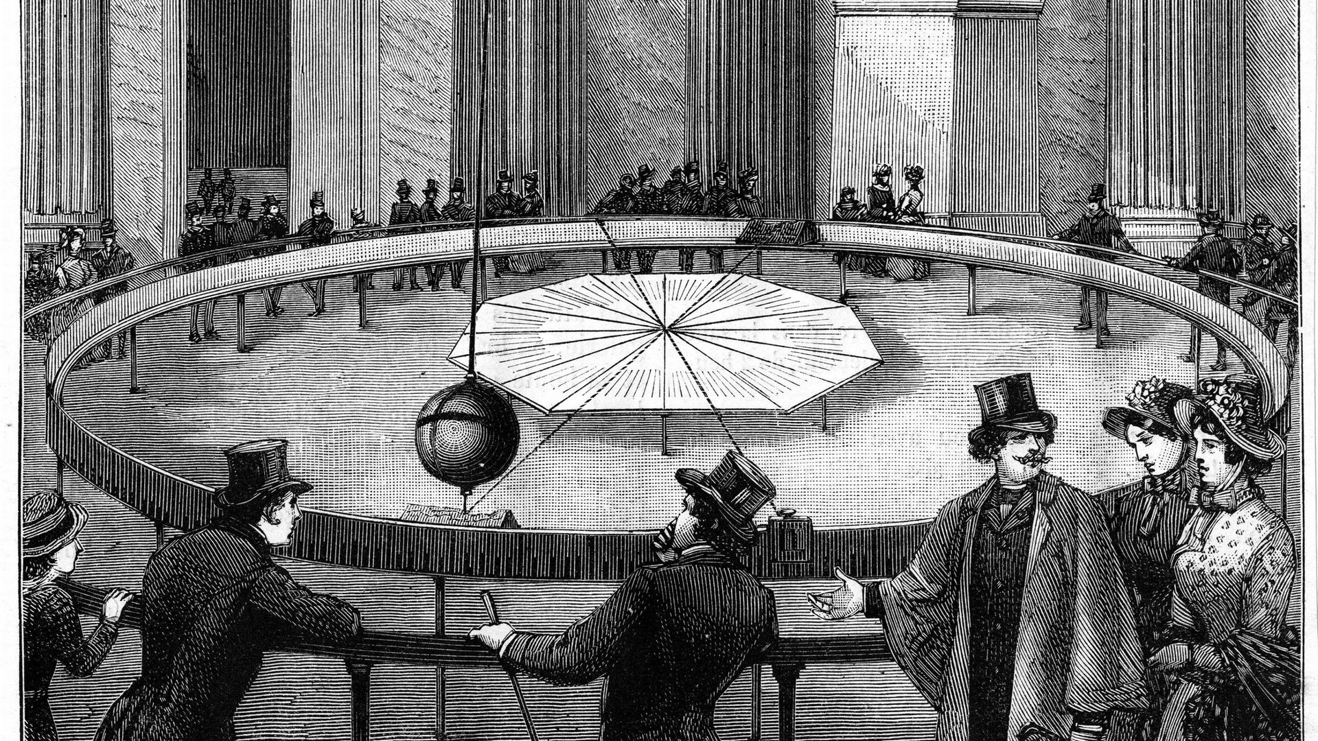 Eine alte Aufnahme zeigt mehrere Menschen, die von der Decke hängendes Pendel beobachten. Eine alte Aufnahme zeigt mehrere Menschen, die von der Decke hängendes Pendel beobachten.