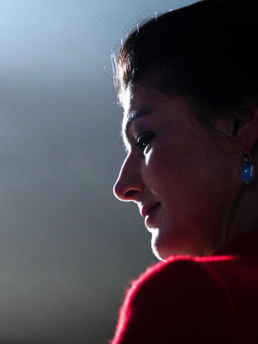 Sahra Wagenknecht ist im Profil vor einem dunklen Hintergrund zu sehen, ihr Gesicht ist beleuchtet