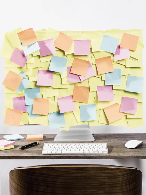 Ein Computerbildschirm ist komplett übersät mit Post-it Zetteln.