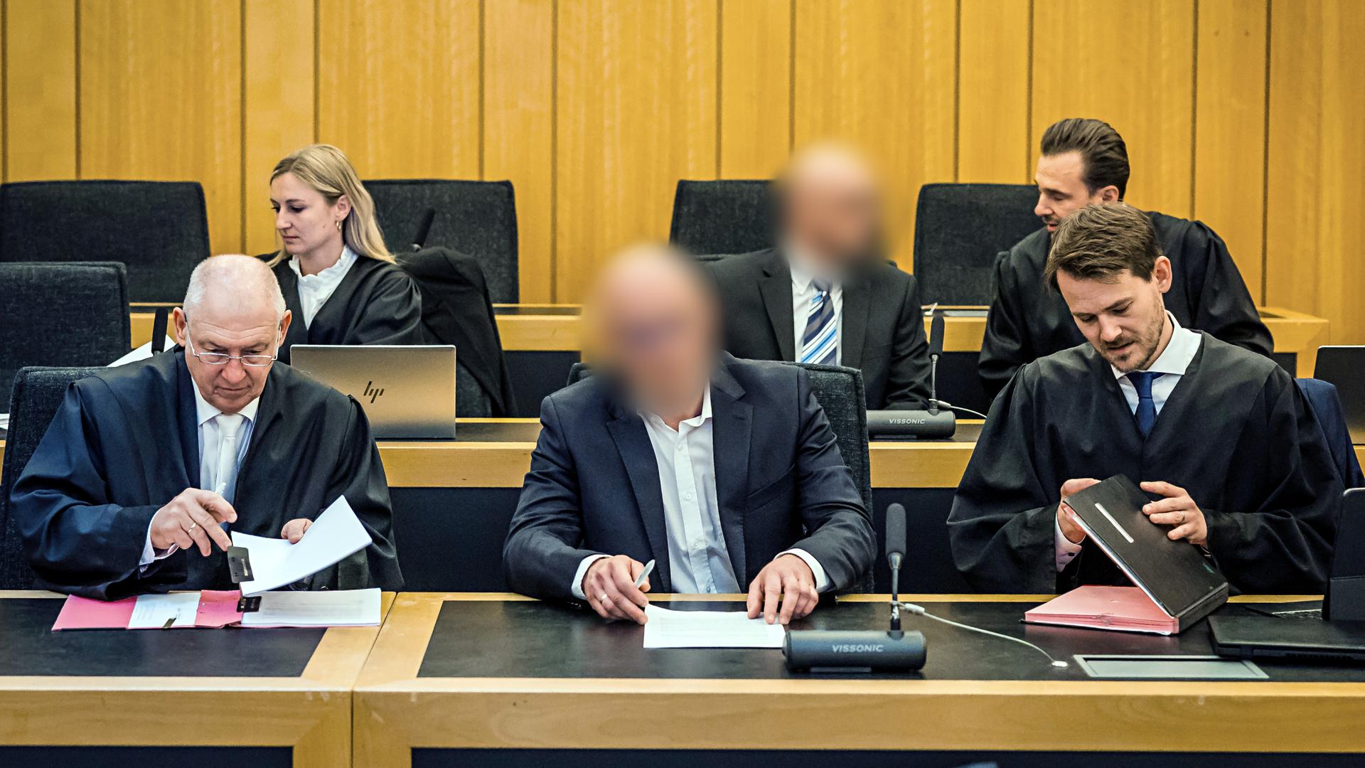 Die beiden Angeklagten sitzen zwischen ihren Anwälten im Gerichtssaal.