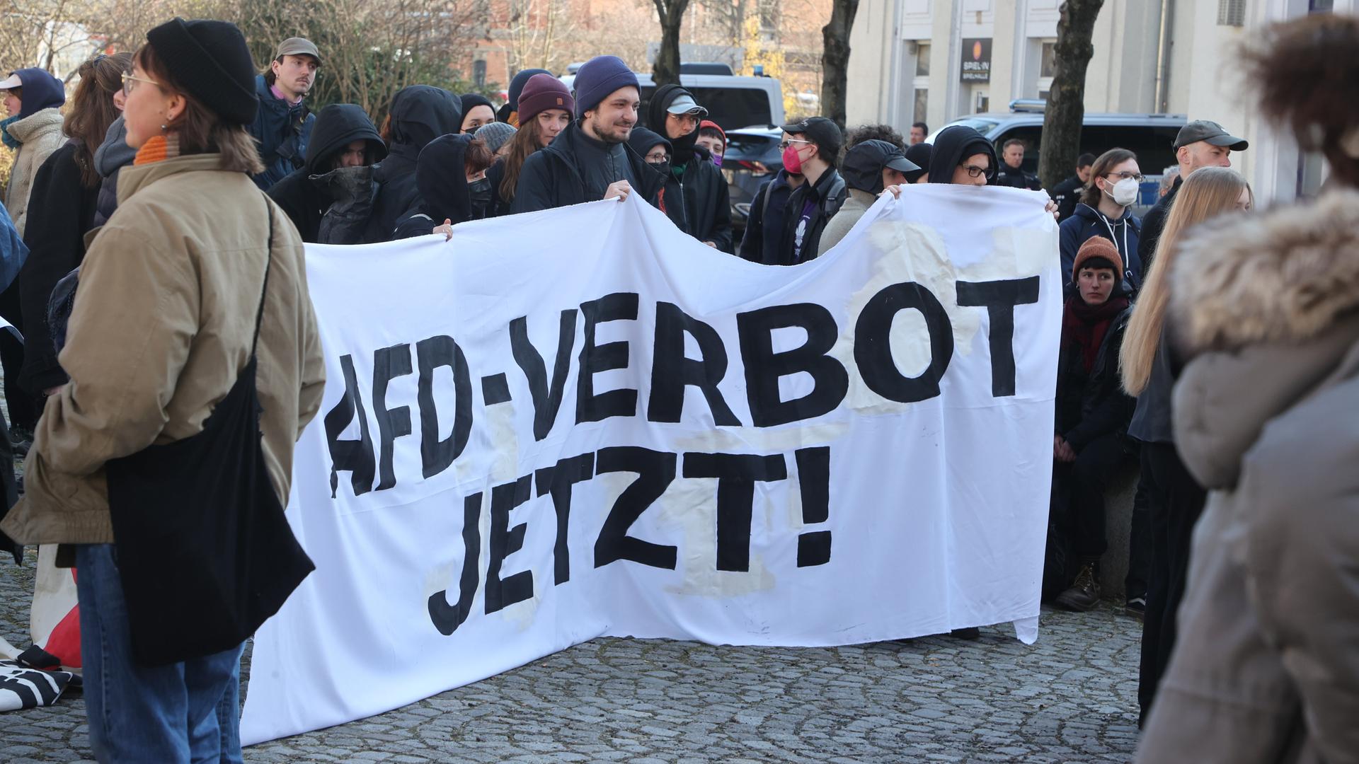 "AfD-Verbot jetzt!" steht auf einem Banner bei einer linken Demo gegen ein rechtes Protestcamp.